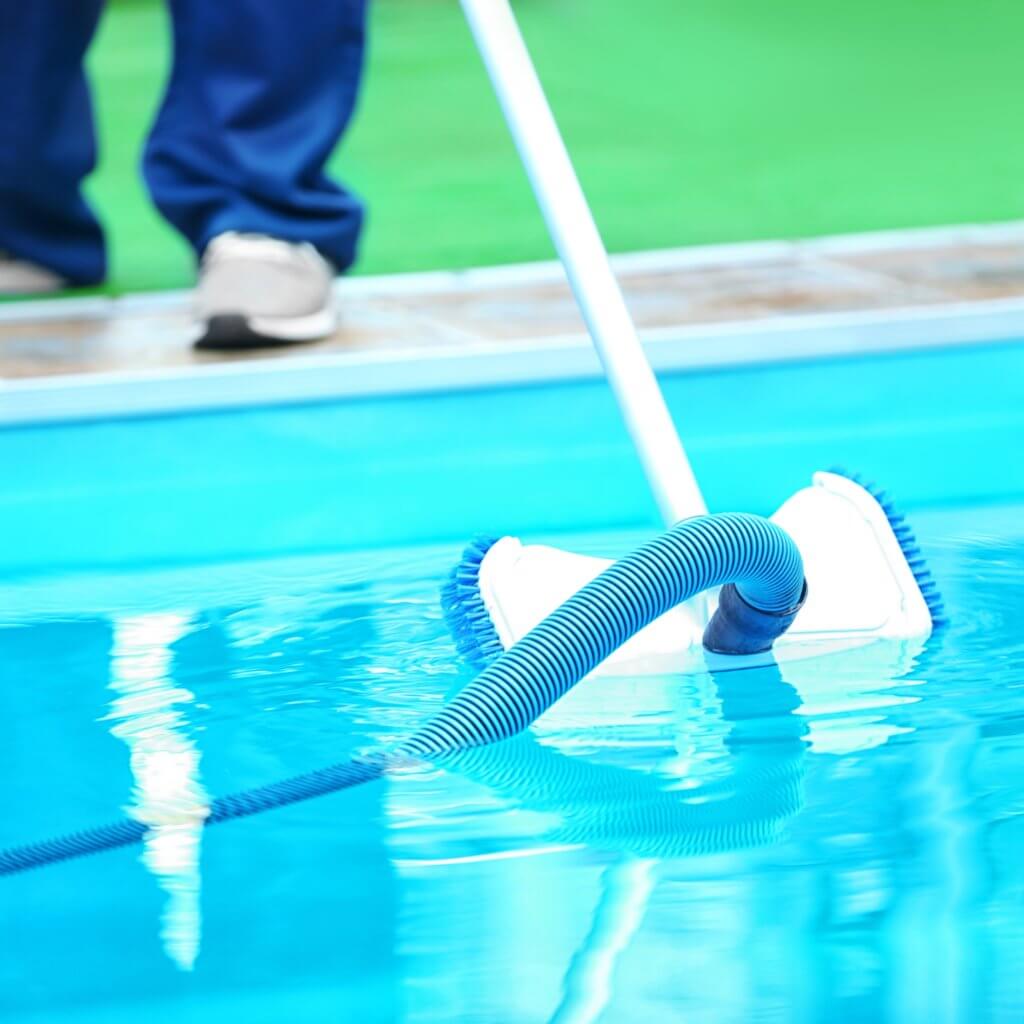 A skilled pool worker cleaning a custom built pool
