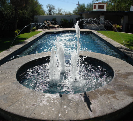 Expertly built custom pool with a water fountain at the end