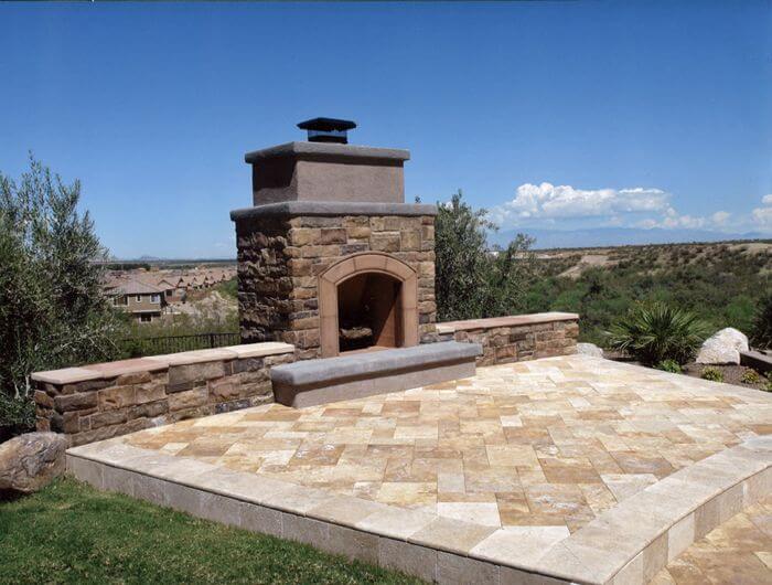 Outdoor fireplace and patio area with a view of hills in Arizona