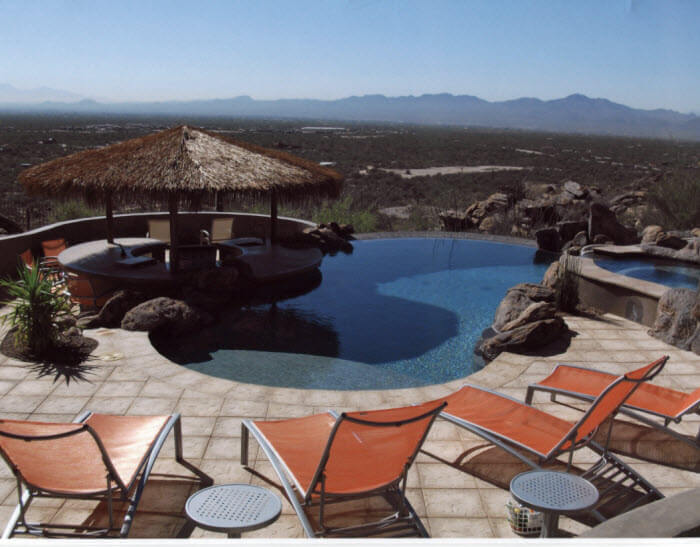 Curved custom pool with a sunken bar area and views of Arizona