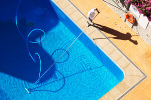 Man vacuuming a swimming pool in Tucson