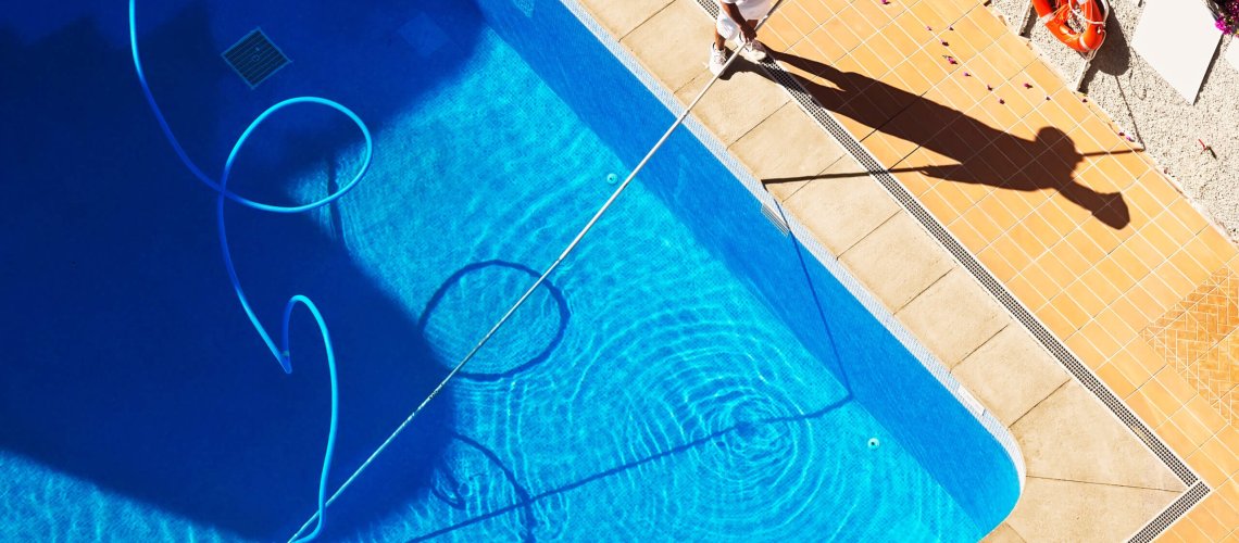 Man vacuuming a swimming pool in Tucson
